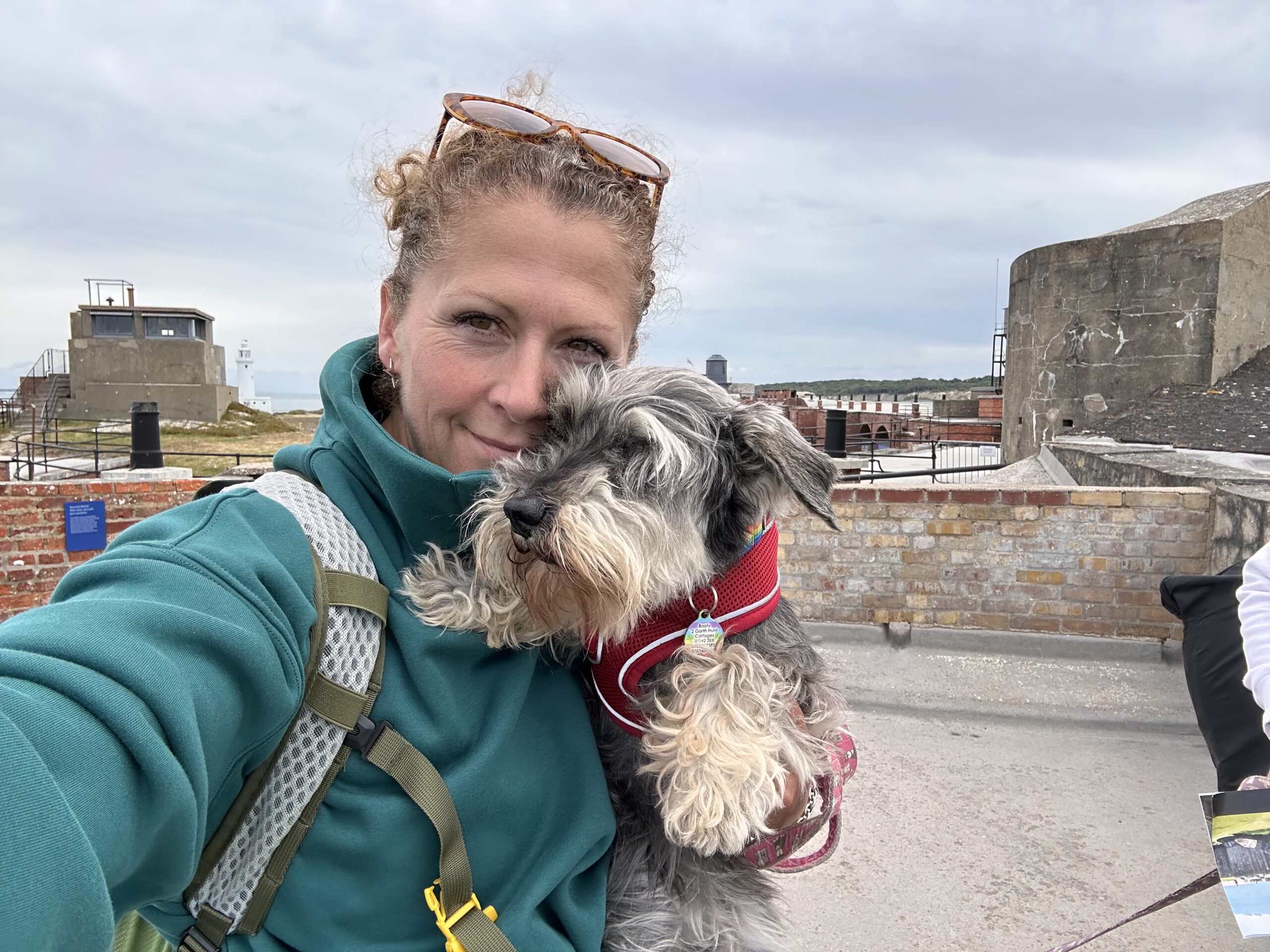 Joanna with one of the dogs at Hurst Castle, lighthouse and battery in the background